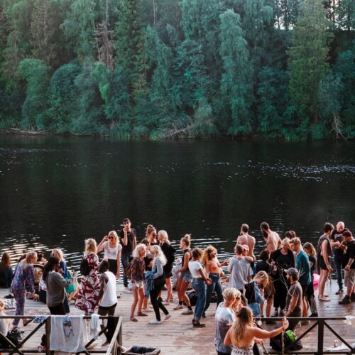 Large group partying by a lake.