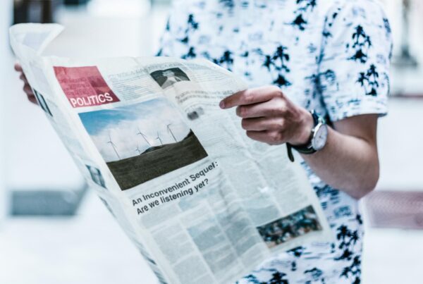 Person reading newspaper about politics.