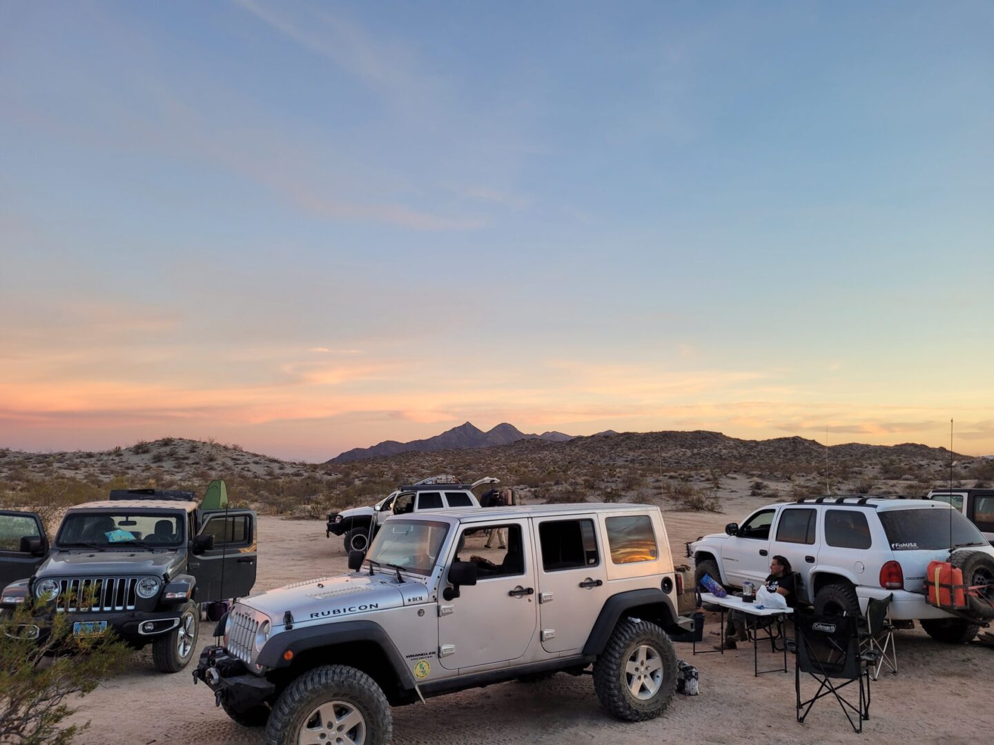 A group of jeep 's parked in the desert.